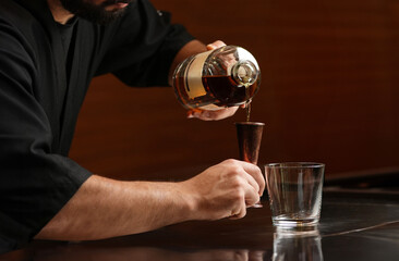 Close-up of barman hand pouring alcoholic cocktail