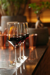 Wine glasses in a row on a bar counter, close-up.