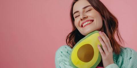 Cheerful Young smiling Woman with Avocado Plushie. Smiling girl hugging a cute avocado stuffed toy, simple background with copy space. - obrazy, fototapety, plakaty