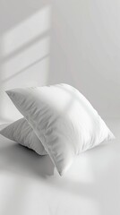 Fototapeta na wymiar Two soft white pillows rest on a plain white floor, creating a minimalist and clean aesthetic.
