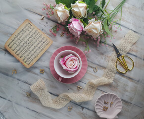 Flower Still life photography, with a composition of cup, lace, scissors and writing paper
