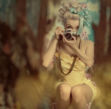 Beautiful young woman with retro camera. Photo in old image style.