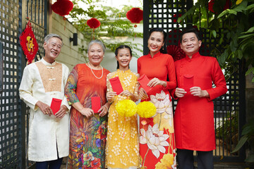Happy Vietnamese family reunited to celebrate Lunar New Year - obrazy, fototapety, plakaty
