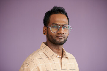 Portrait of serious confident software developer in glasses looking at camera