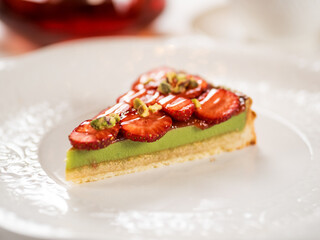 Piece of pistachio cake decorated strawberries
