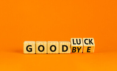 Good luck or goodbye symbol. Concept words Good luck or Goodbye on beautiful wooden blocks. Beautiful orange table orange background. Business, motivational good luck concept. Copy space.