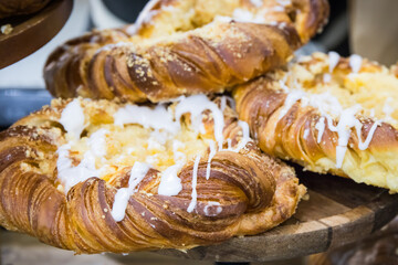 Crusty bun with icing on market stall, in cafe or in confectionery shop