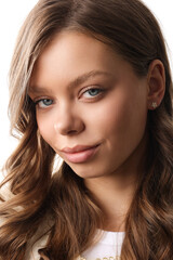 Fototapeta premium Beautiful young girl with fresh healthy skin. Woman advertise ear-rings. White background. Earrings closeup. Blond european woman with long hair with big lips, pretty smile. Cosmetology, scincare