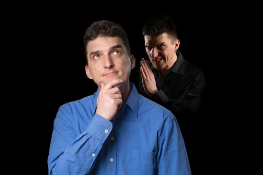 A friendly-looking young man to whom his evil inner voice is whispering something from the shadow behind