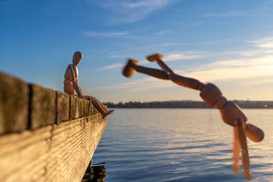 Besonderes Foto eines Liebespaars an einem Holzsteg dargestellt mit hölzernen Gliederpuppen