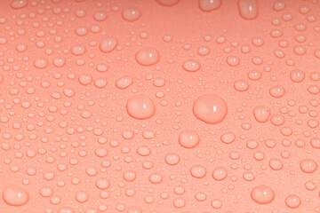 the orange surface is covered with water droplets of different sizes