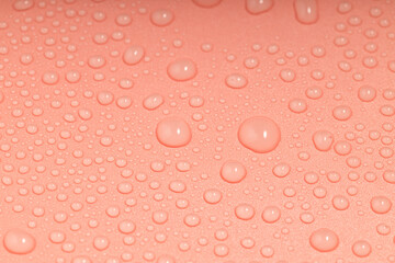 the orange surface is covered with water droplets of different sizes