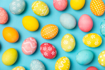 Easter eggs on a bright blue background. Easter celebration concept. Colorful easter handmade decorated Easter eggs. Place for text. Copy space.