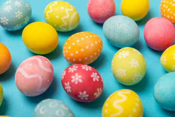 Easter eggs on a bright blue background. Easter celebration concept. Colorful easter handmade decorated Easter eggs. Place for text. Copy space.