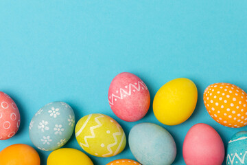Easter eggs on a bright blue background. Easter celebration concept. Colorful easter handmade decorated Easter eggs. Place for text. Copy space.