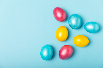 Easter eggs on a bright blue background. Easter celebration concept. Colorful easter handmade decorated Easter eggs. Place for text. Copy space.