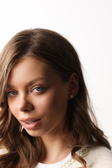 Fototapeta premium Beautiful young girl with fresh healthy skin. Woman advertise ear-rings. White background. Earrings closeup. Blond european woman with long hair with big lips, pretty smile. Cosmetology, scincare