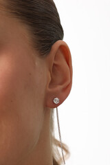 Beautiful young girl with fresh healthy skin. Woman advertise ear-rings. White background. Earrings closeup. Blond european woman with long hair with big lips, pretty smile. Cosmetology, scincare