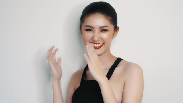 Happy asian woman dancing against white background Beautiful asia young lady wear black dress and ready going to party Studio portrait of a young woman dancing