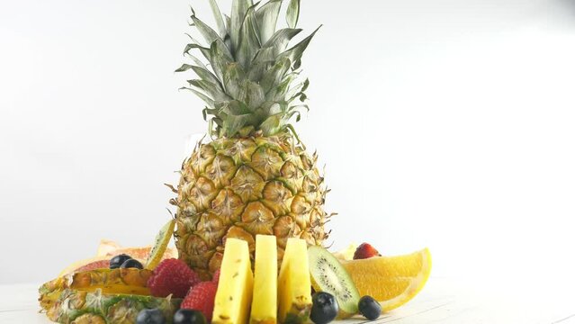 A pineapple. Juicy and ripe. With slices and berries and fruits