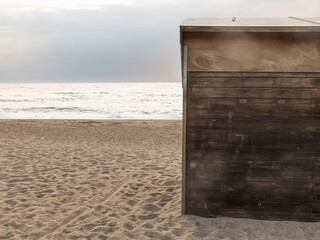 A solitary wooden cabin door stands on a tranquil beach,