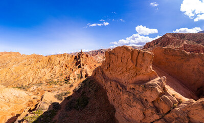Fototapeta na wymiar Aerial top view to beautiful landscape of Skazka canyon. Rocks Fairy Tale - famous destination in Kyrgyzstan. Rock formations in shape of a dragon spine like great wall of china on Issyk-Kul lake.