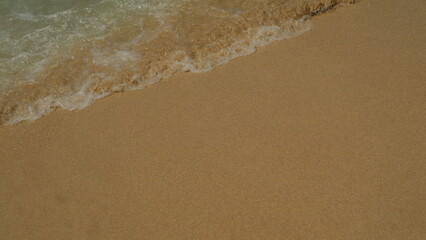 Footage of small waves splashing on the sand beach with pebbles, nature background