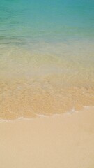 Fototapeta na wymiar Footage of small waves splashing on the sand beach with pebbles, nature background