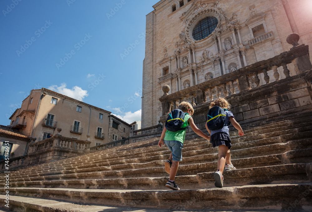 Wall mural two blond kids explore girona, go up big stairs of cathedral