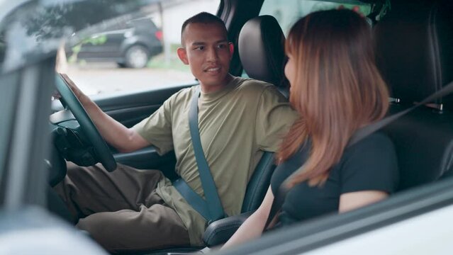 Couple is cheering each other on in the car while leaving. Transportation travel concept.