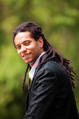 Brazilian individual with stylish rastas, dressed in a suit while strolling in a park - 745180934