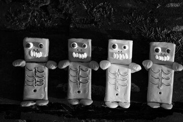 Toy monsters lie on a dark wooden background. Black and white photo.