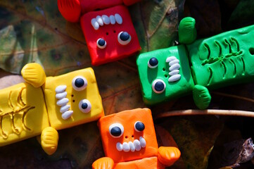 Toy monsters lie on autumn leaves. Halloween decorations.