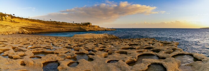 panorama view of the tidal pools and cliffs at Il-Hofra z-Zghira Bay in Malta