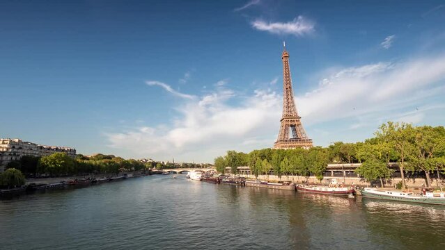 PARIS, FRANCE - FEBRUARY 20, 2024 : Timelapse motion hyperlapse view of the Eiffel Tower and Champ de Mars on embankment of the Seine River, famous touristic landmark.