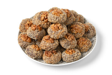 Plate with traditional fresh baked Moroccan Ghoriba cookies topped with a walnut close up isolated on white background
