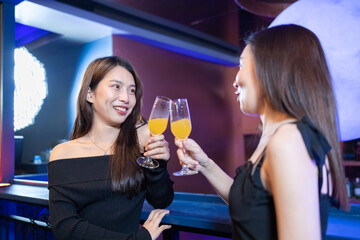 Women Friends Enjoying Drinks at Elegant Bar