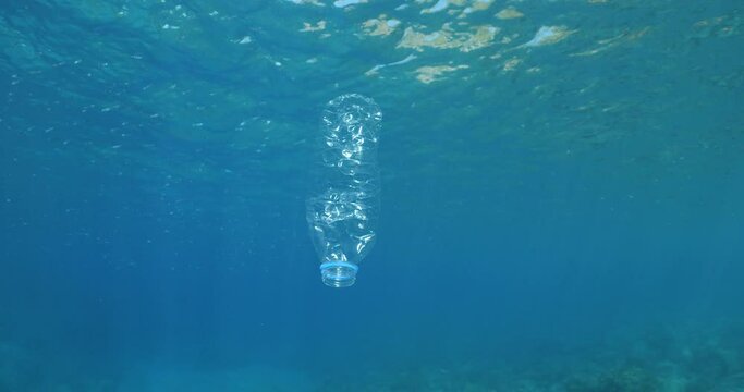 plastic bottle  underwater ocean pollution with sun beams and rays