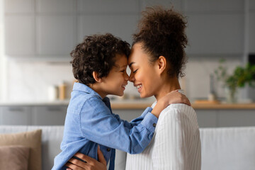 Loving moment as black mother and son share tender forehead touch - obrazy, fototapety, plakaty