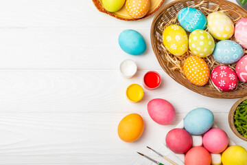 Easter egg painting at the kitchen table.Happy Easter celebration concept.Colorful Easter eggs with different patterns.Paints,decorations for coloring eggs for holiday.Creative background.Copy space
