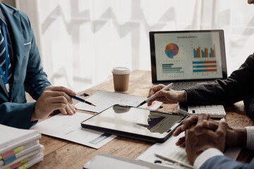 Business people meeting in a business presentation or seminar, documents, graphs and financial or marketing charts are There is a laptop and digital tablet on the table. Close-up shot