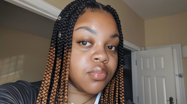medium complexion young Black woman with long, brown ombre knotless braids