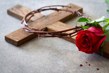 Red rose, wooden cross and crown of thorns. Passion of Christ symbol, concept