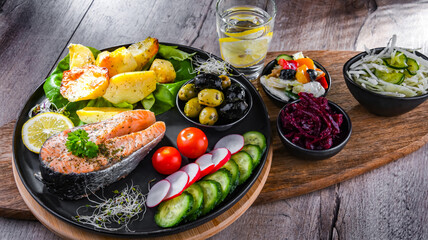 Fried salmon with potatoes and vegetable salads