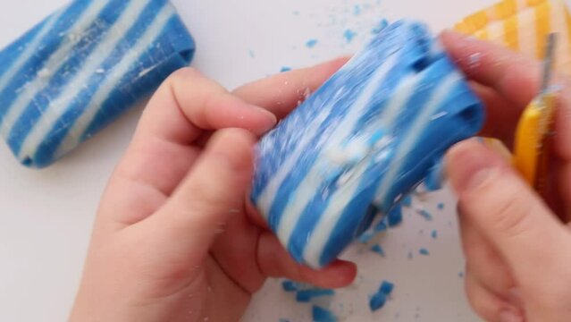 With a knife, he cuts striped colored soap into square, small pieces. Asmr.
