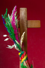 Traditional colorful palm and wooden cross on red background. Palm Sunday concept