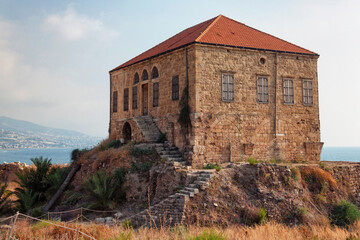 View of the old traditional Lebanese stone house over the Mediterranean sea in Byblos, Lebanon. The house is part of the ancient archaeological complex located next to it.
