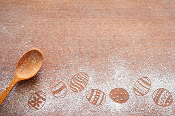 Easter eggs made of flour on chopping board with wooden spoon, easter baking background concept, copy space