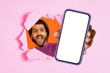 Excited man with a beard joyously breaking through a pink torn paper