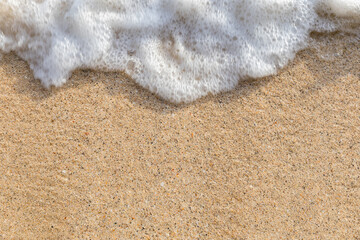 Soft wave of ocean on sandy beach. Wave of the sea on the sand beach. White sand beach and blue sky.
